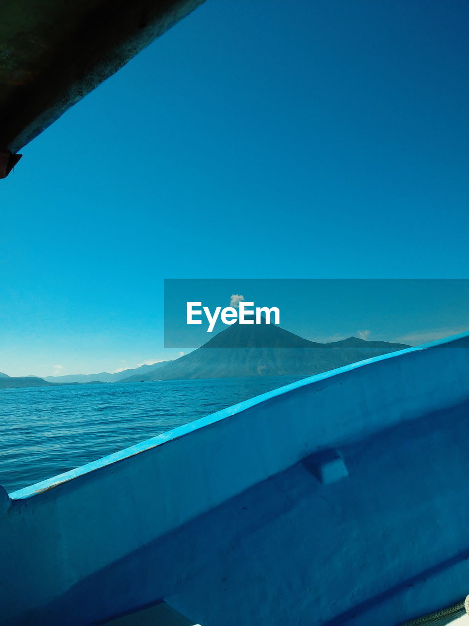 Lake atitlan by mountain against sky seen from boat