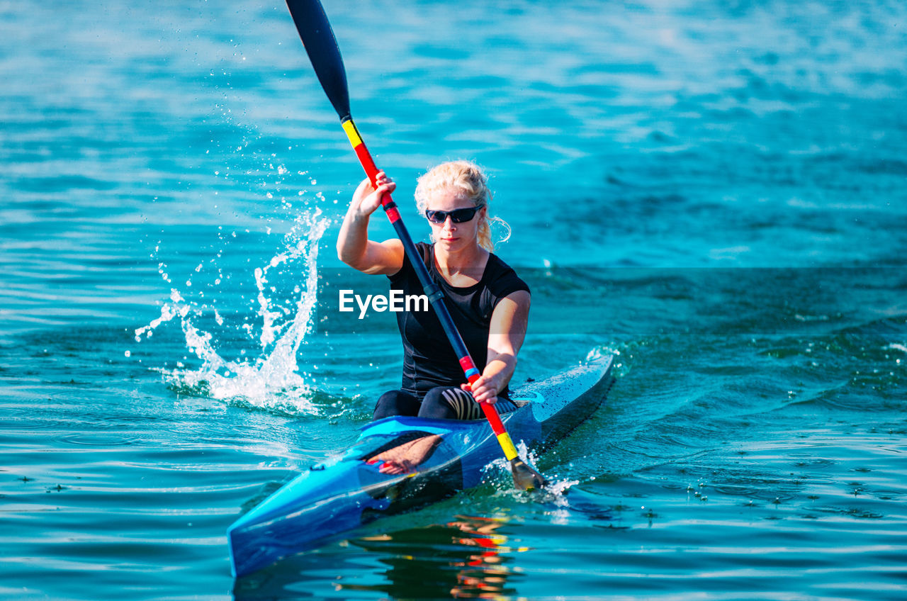 Young woman kayaking on lake