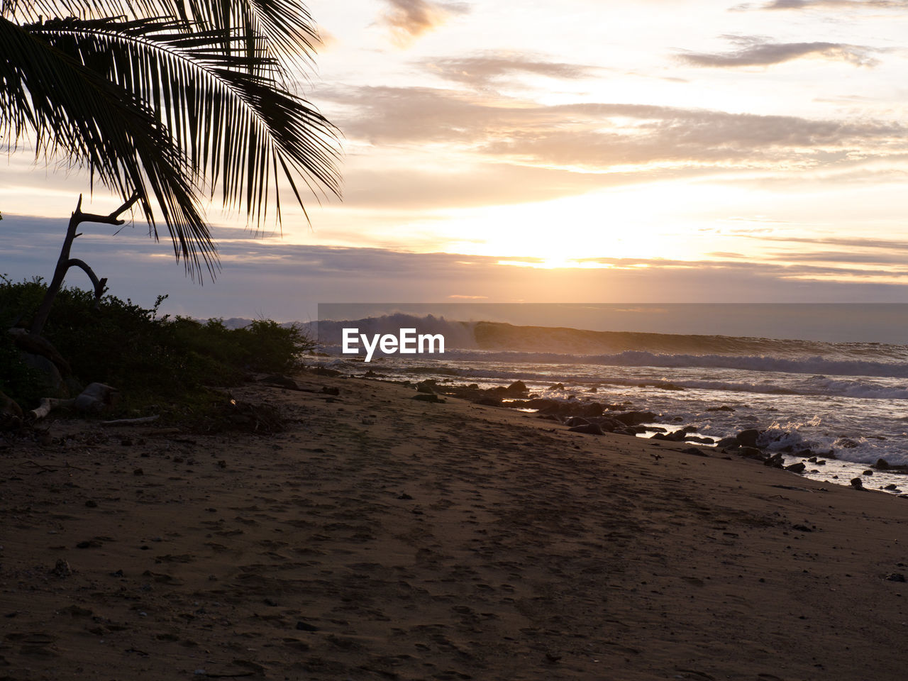 Scenic view of beach against sky during sunset