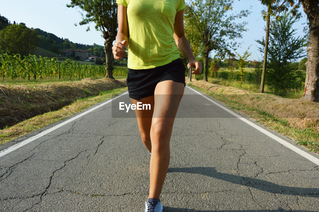 Low section of woman jogging on road