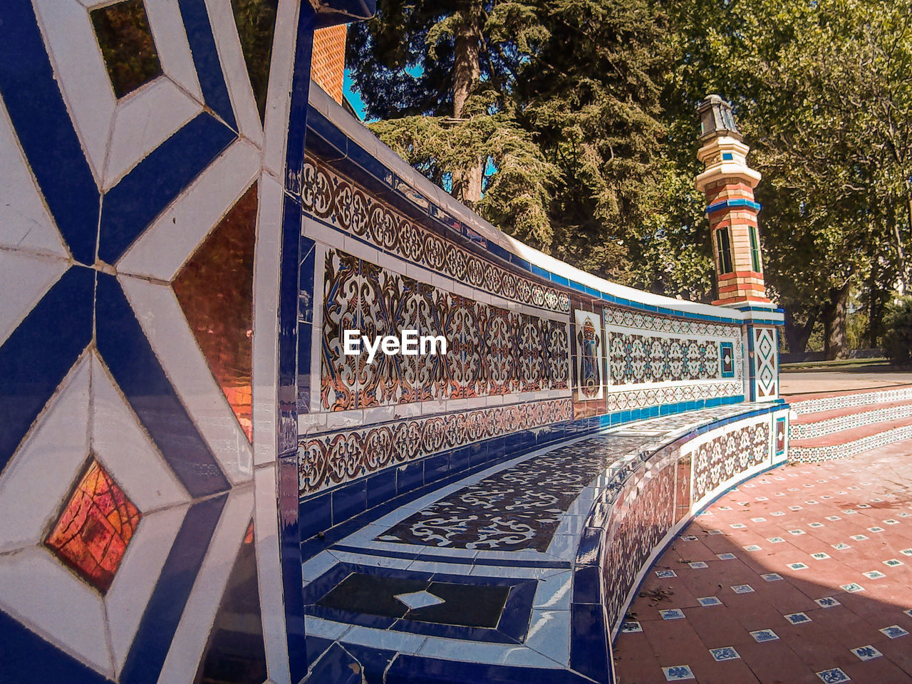 Close up of a bench made of colorful tiles at the retiro park in madrid, spain. sunlight and shadows