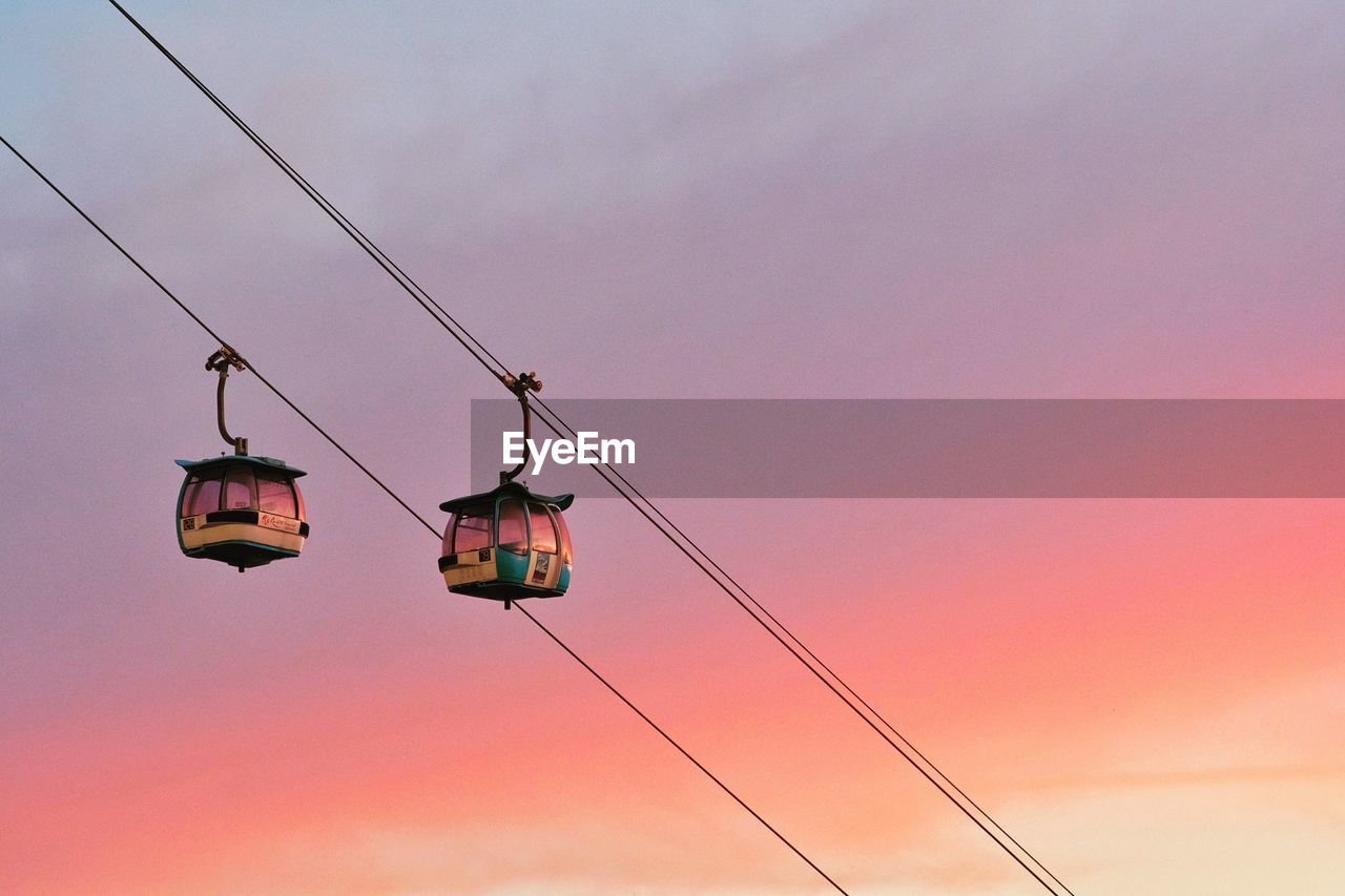 Low angle view of overhead cable car against sky during sunset