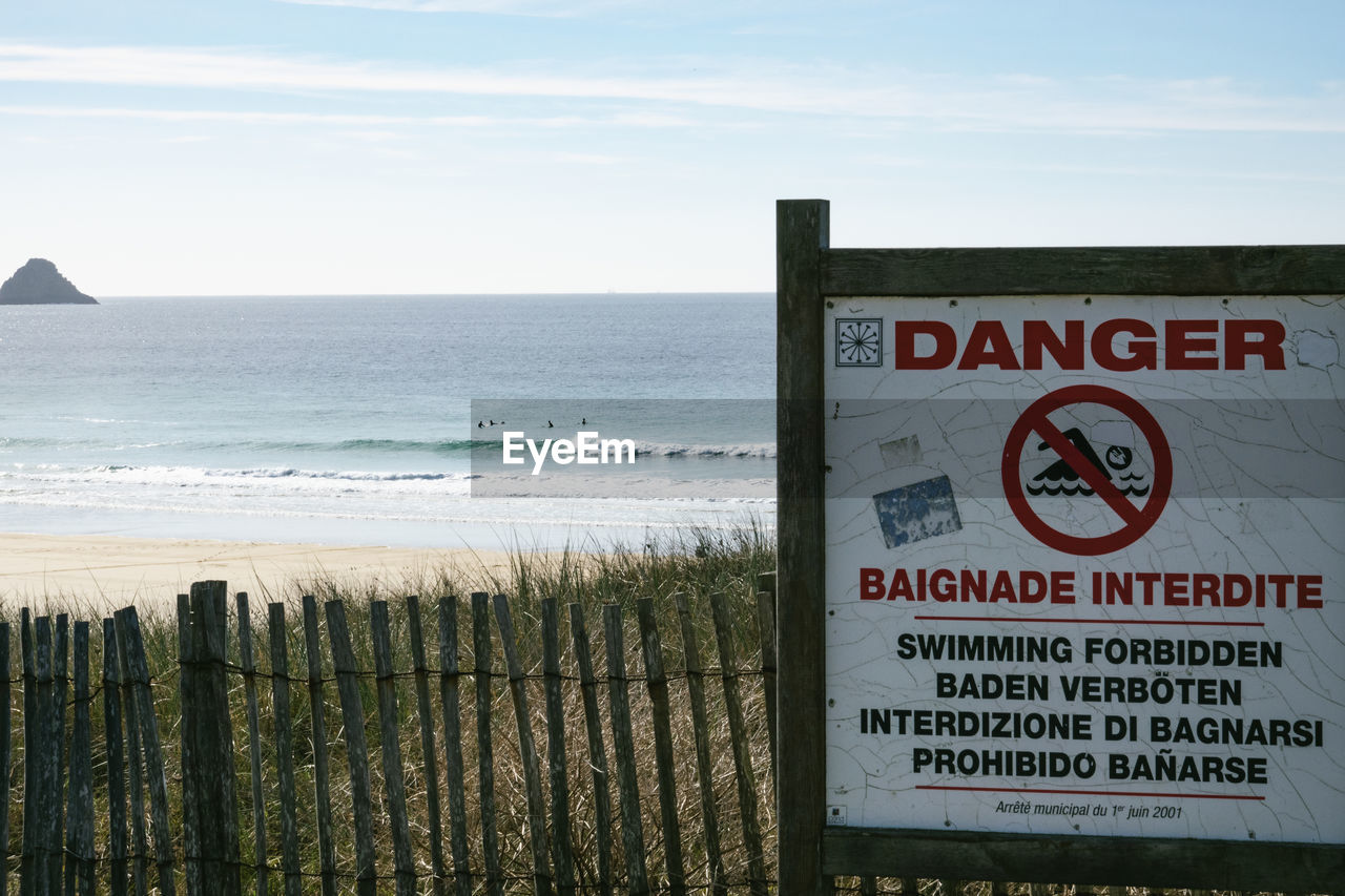 INFORMATION SIGN ON SHORE AGAINST SKY