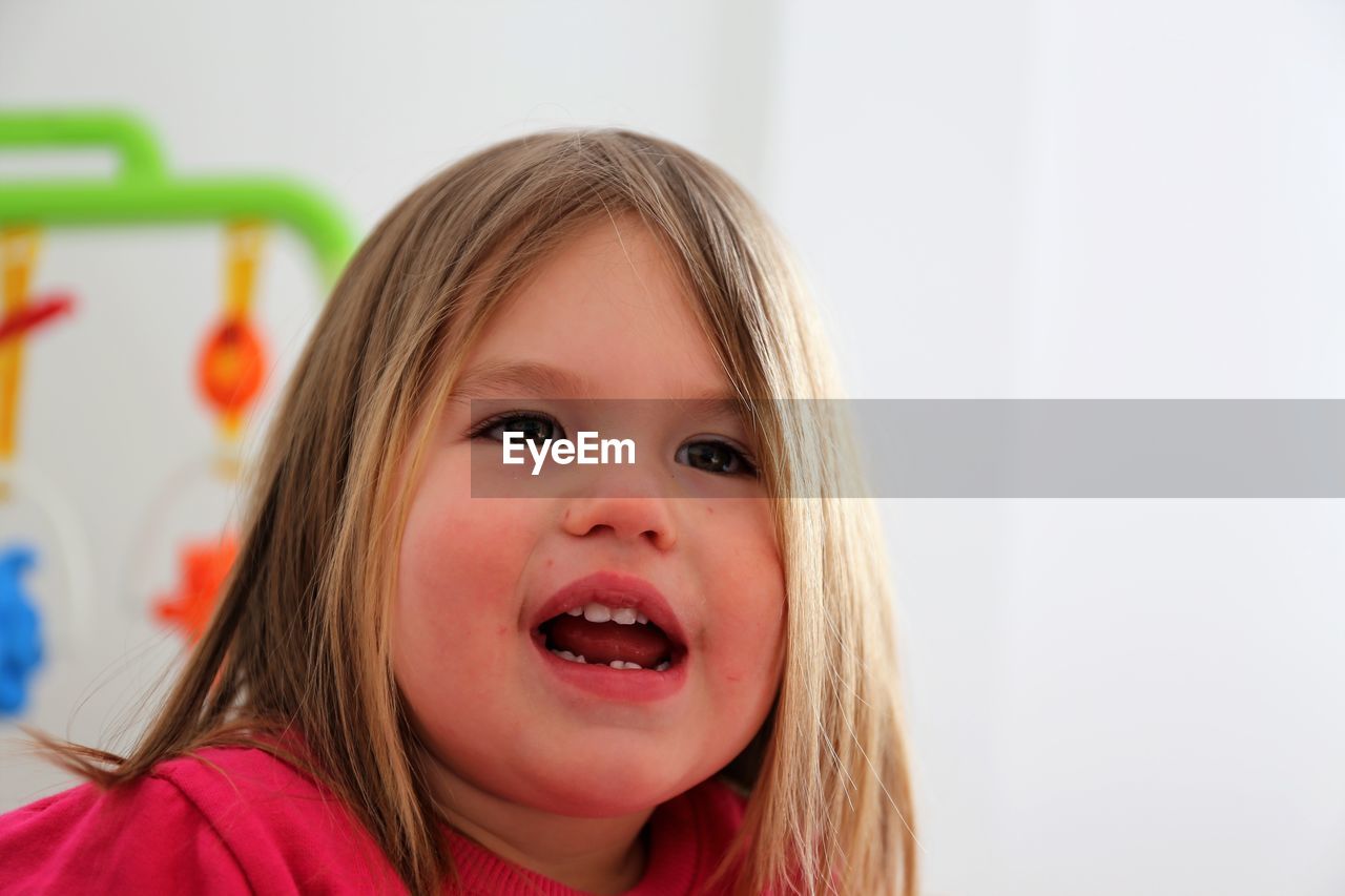 Close-up portrait of cute girl at home