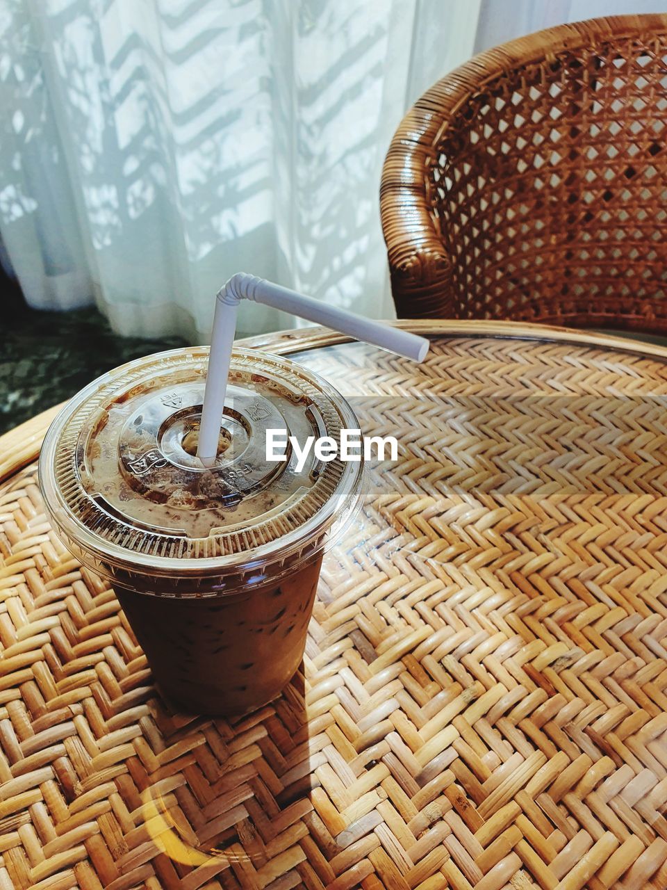 Iced coffee cup on weave furniture with nature light