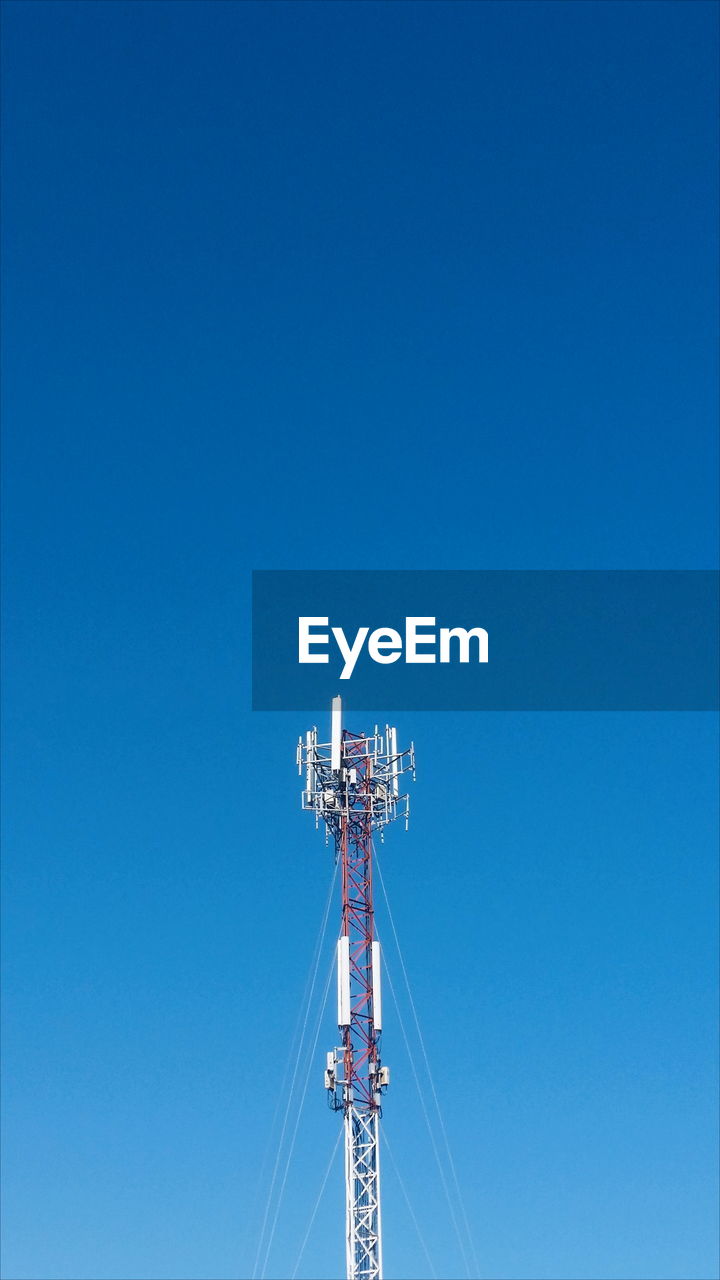 Low angle view of communication tower against clear blue sky