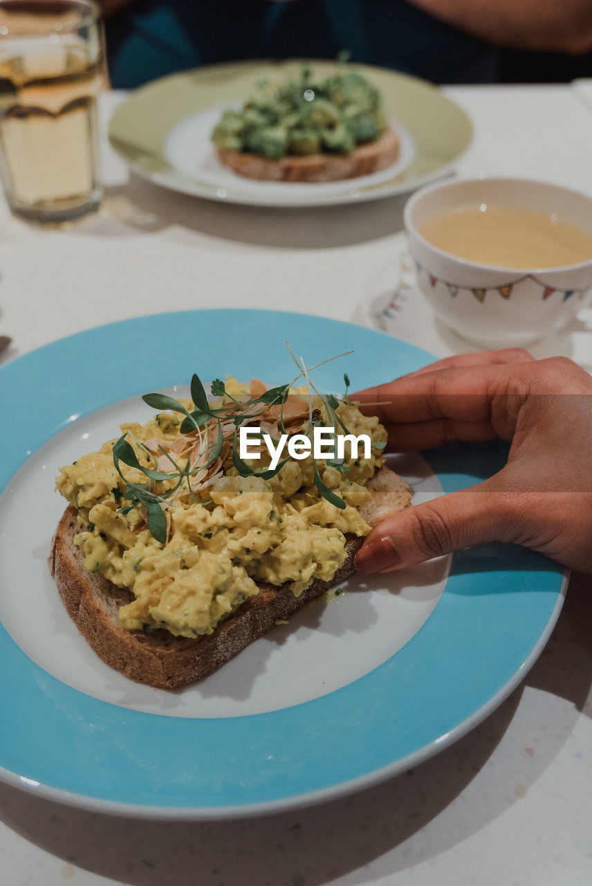 Close-up of hand holding food served in plate