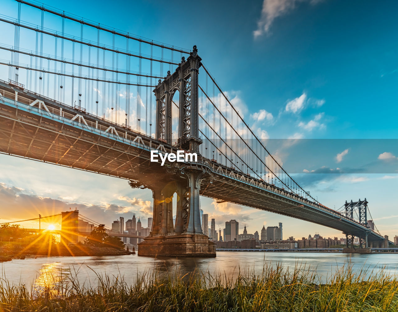 Bridge over river with city in background, brooklyn bridge 