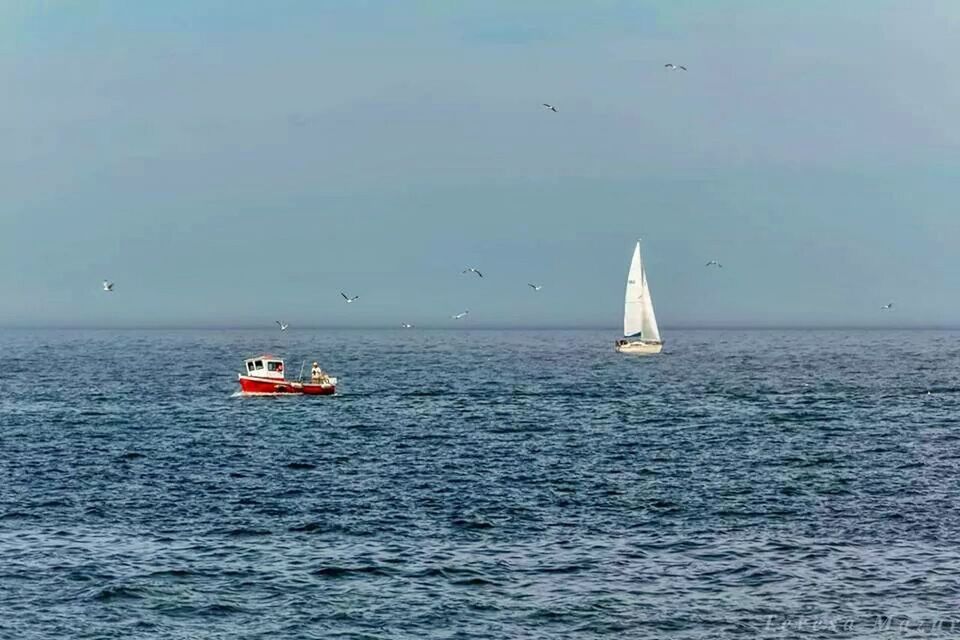 View of boats in calm blue sea