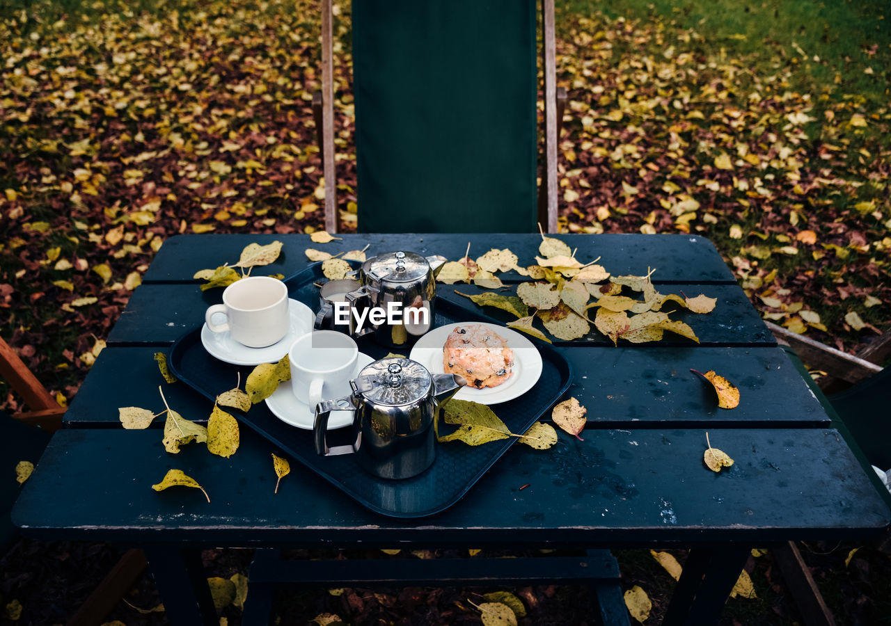 High angle view of autumn leaves by breakfast in tray on table