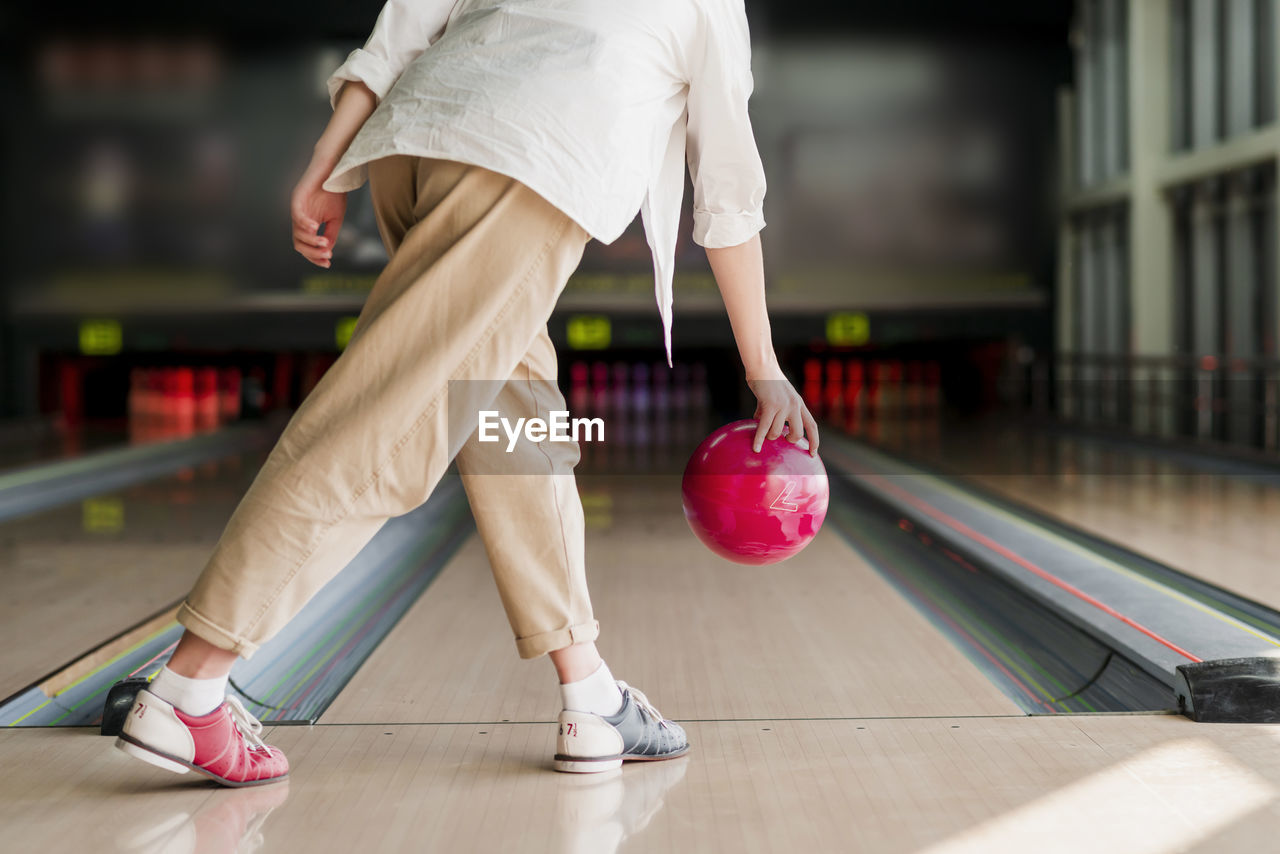 Low section of woman playing bowling