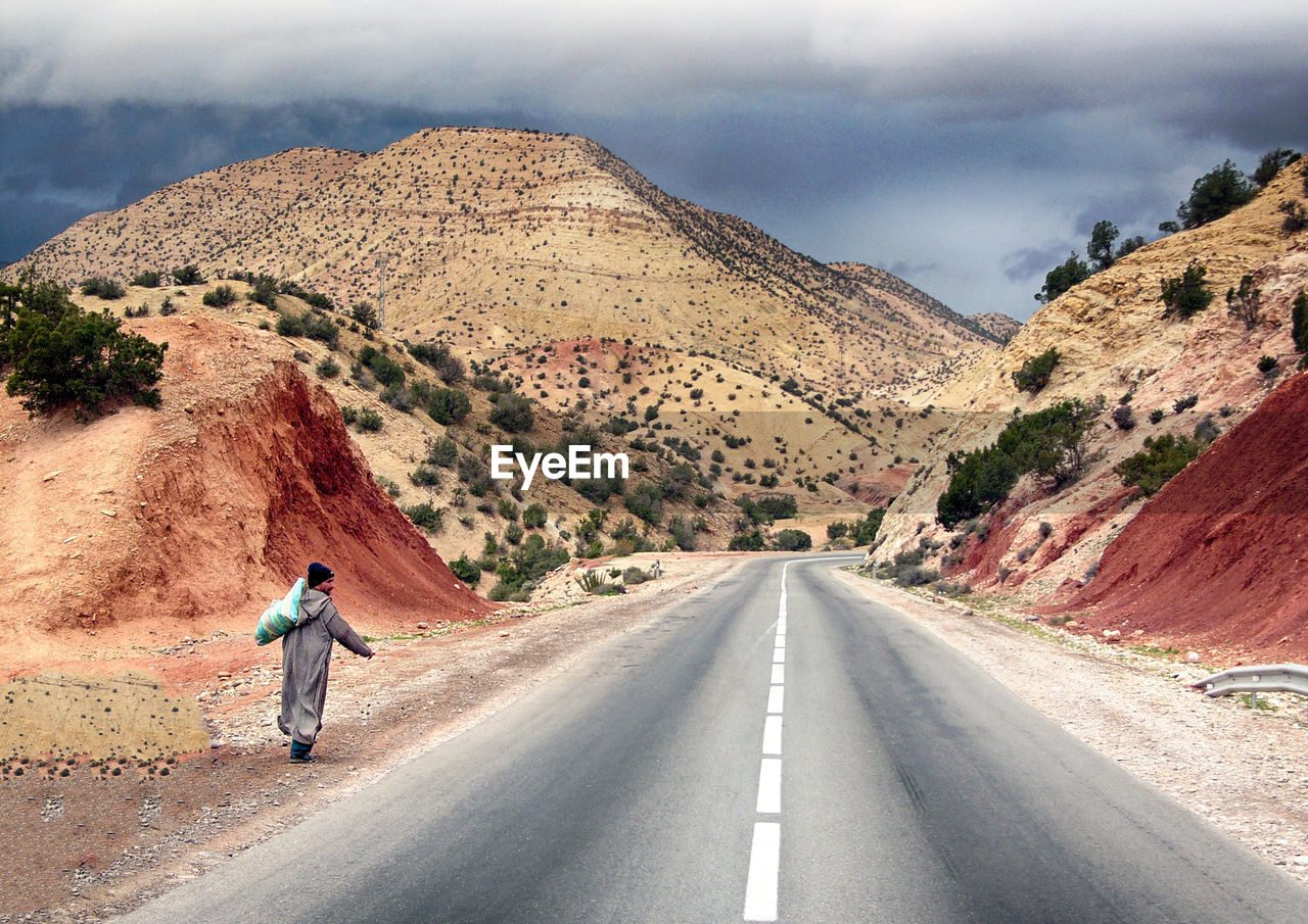 FULL LENGTH REAR VIEW OF MAN ON ROAD