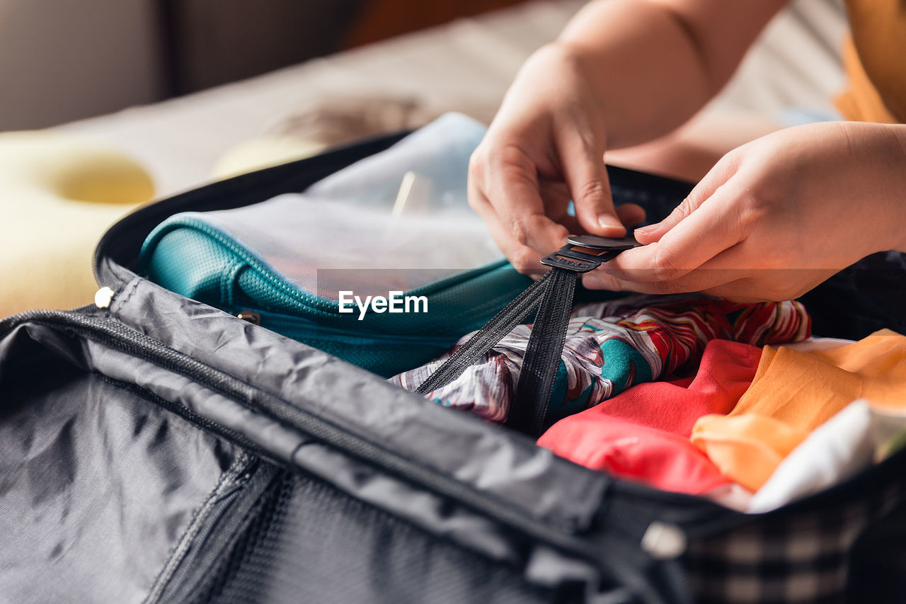 Hands of woman packing suitcase