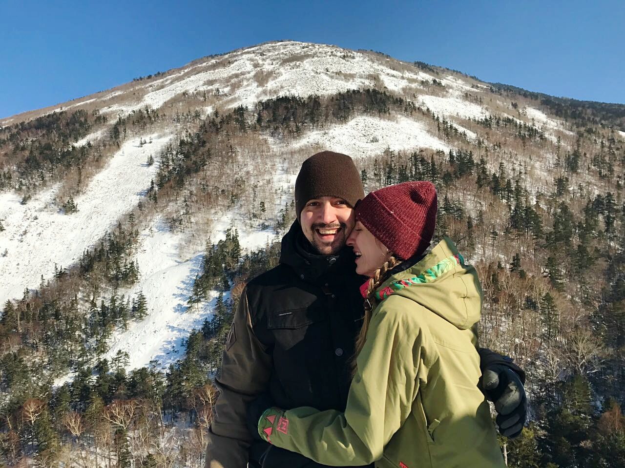 Portrait of a young couple against snow covered mountain