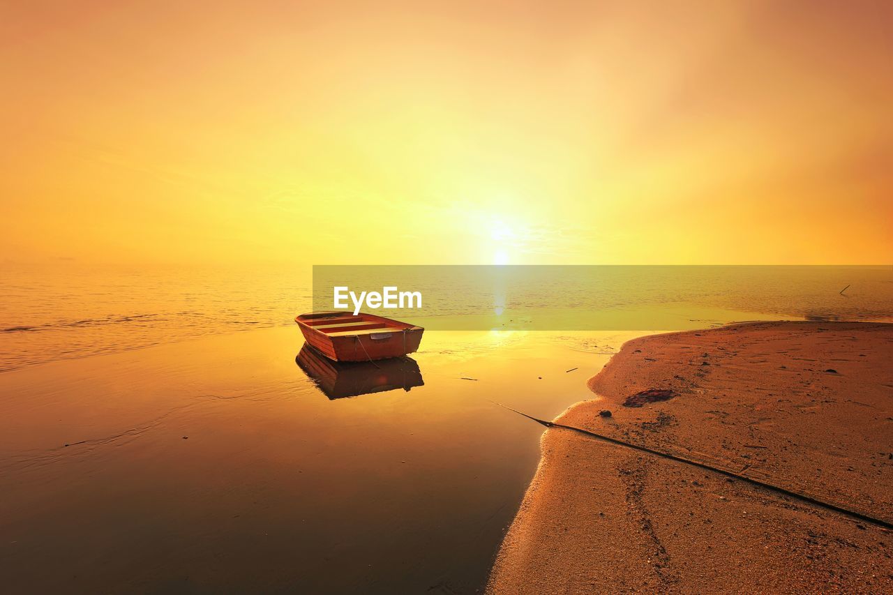 Boat on sea against sky during sunset