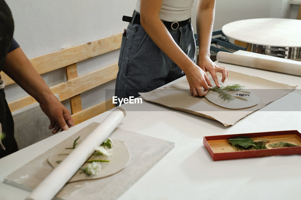 Pottery workshop in studio. person working with clay by the table. adults learning to do ceramic