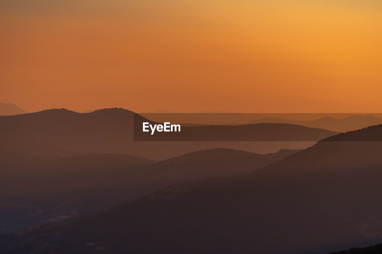 Scenic view of silhouette mountains against sky during sunset