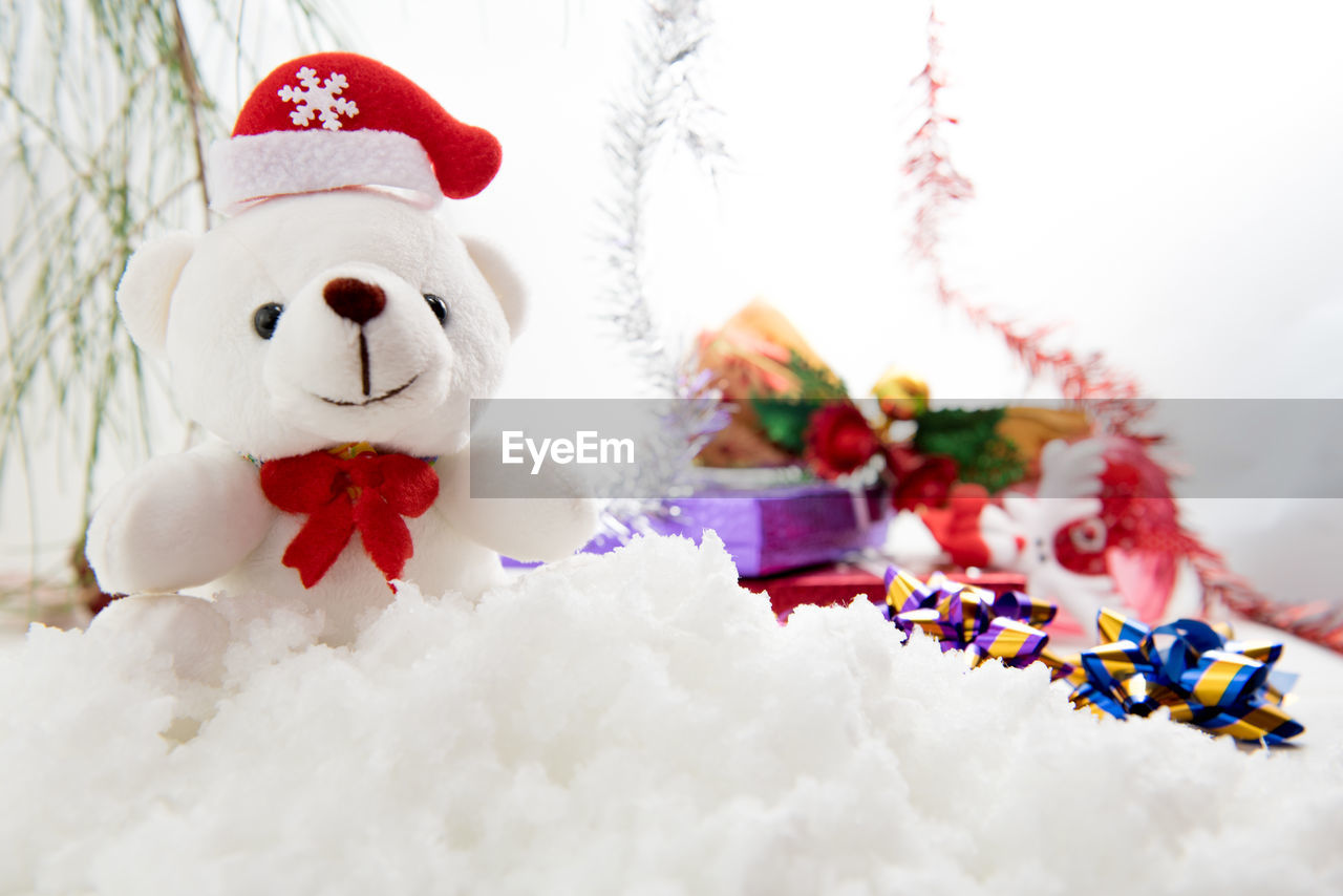 Teddy bear and christmas presents on fake snow