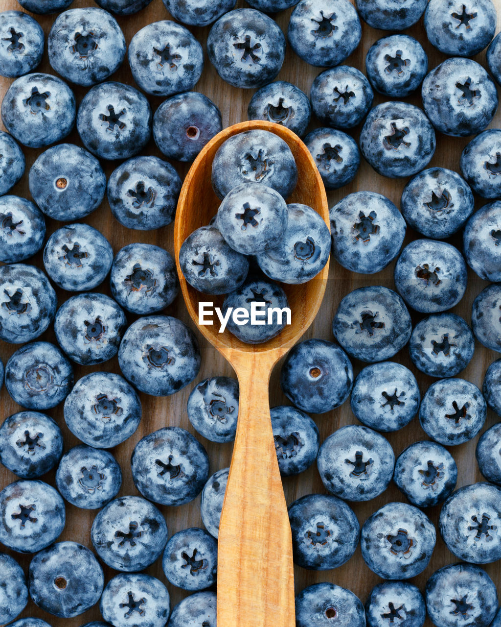 Fresh blue berries in a wooden spoon