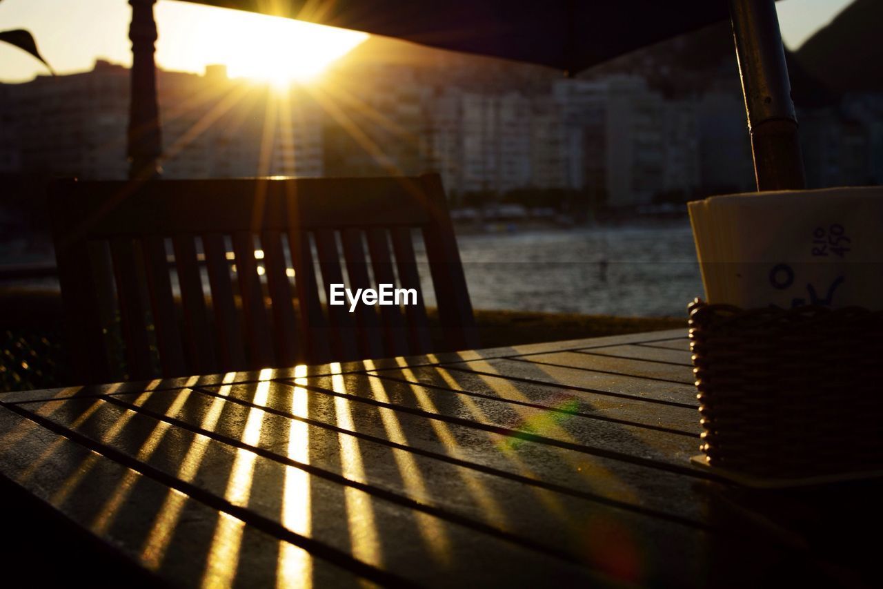 Close-up of table and chair at sunset