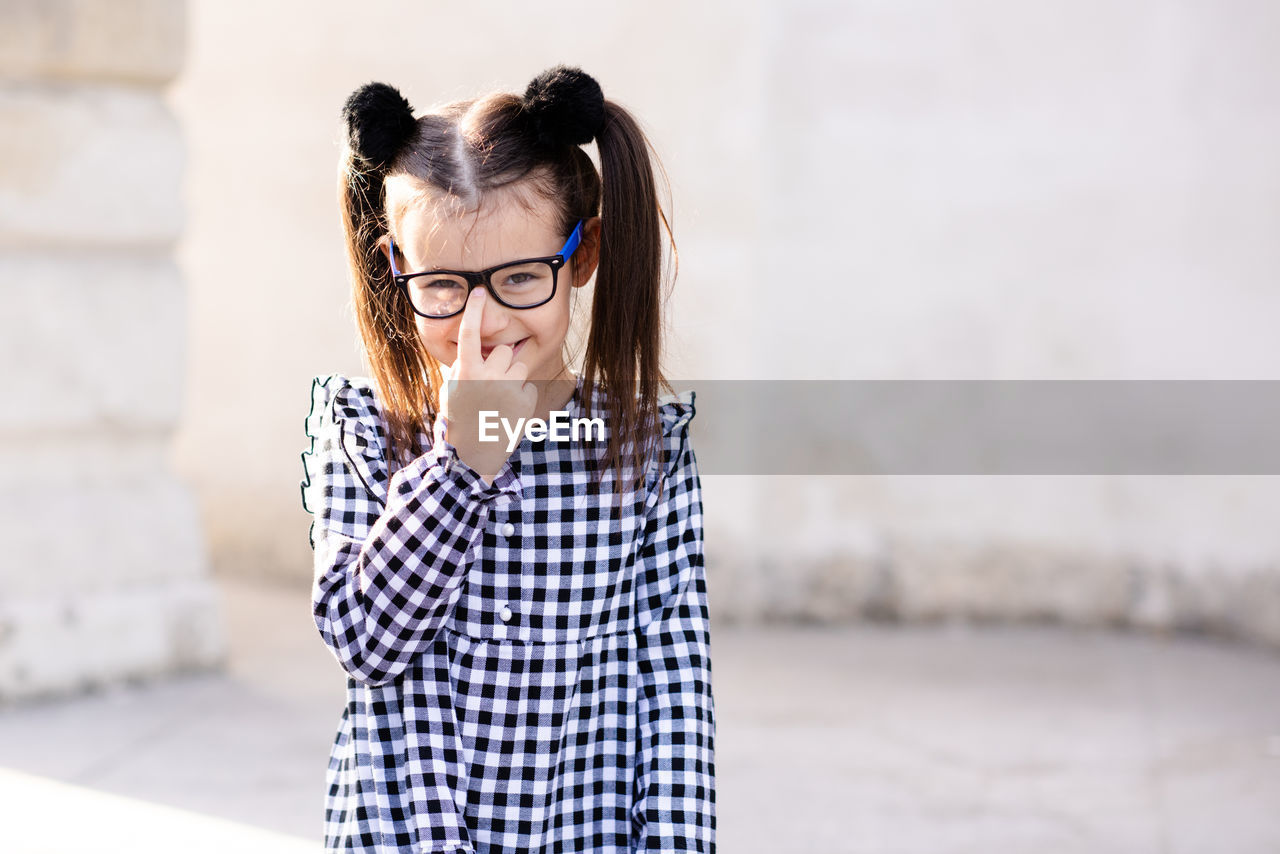 Cute little pupil girl 5-6 year old wear glasses and casual stylish dress. back to school. 