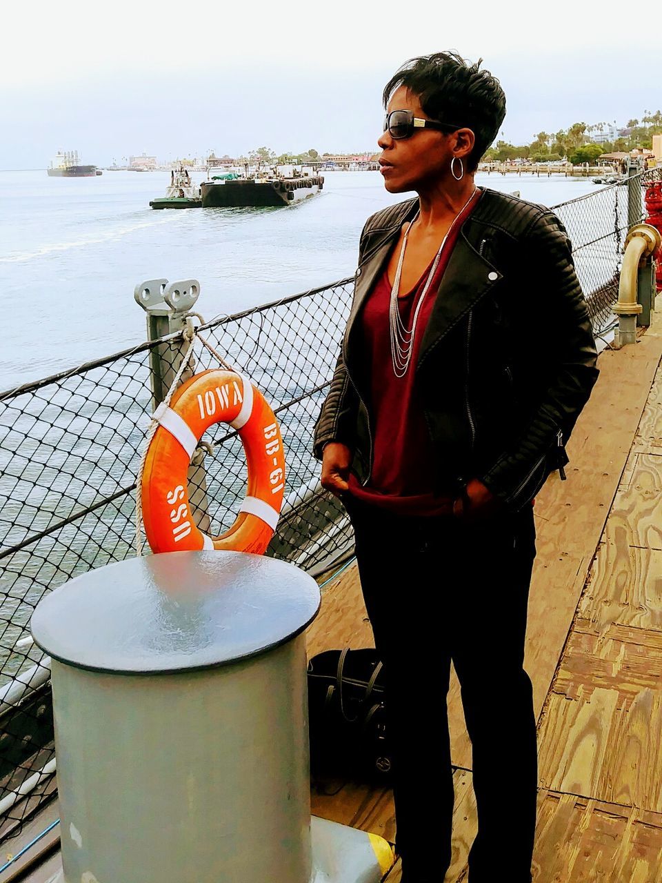 PORTRAIT OF YOUNG WOMAN STANDING AGAINST SEA