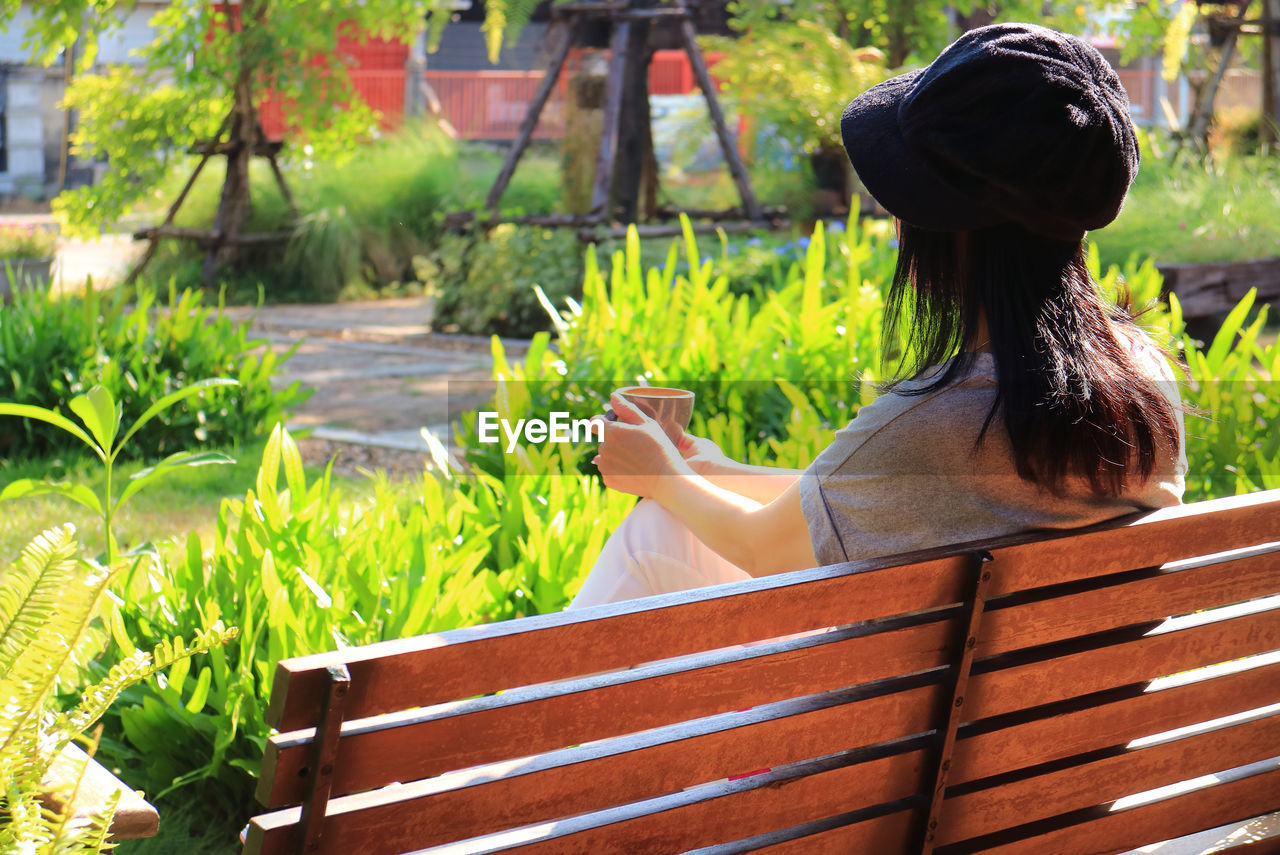 Rear view of woman sitting at park