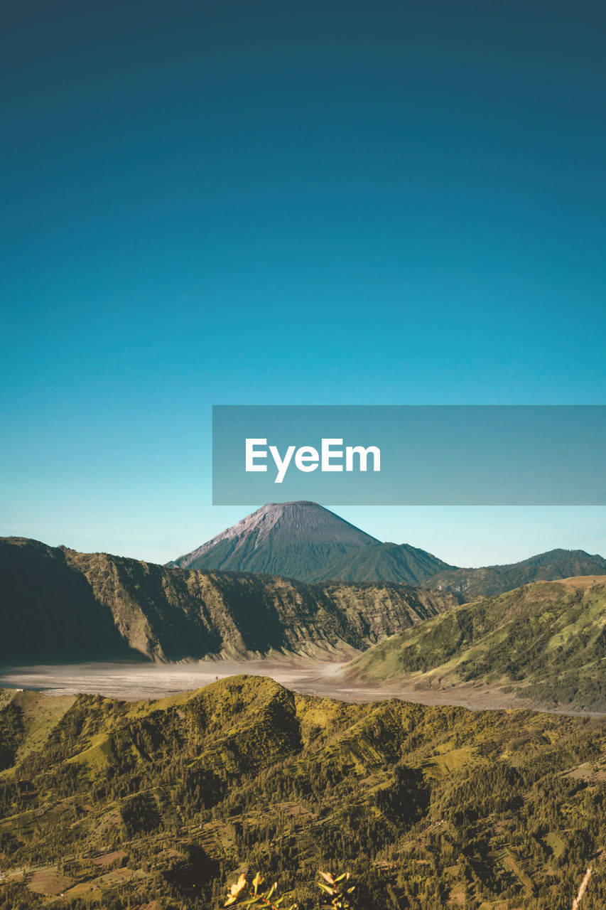 Scenic view of mountains against clear blue sky