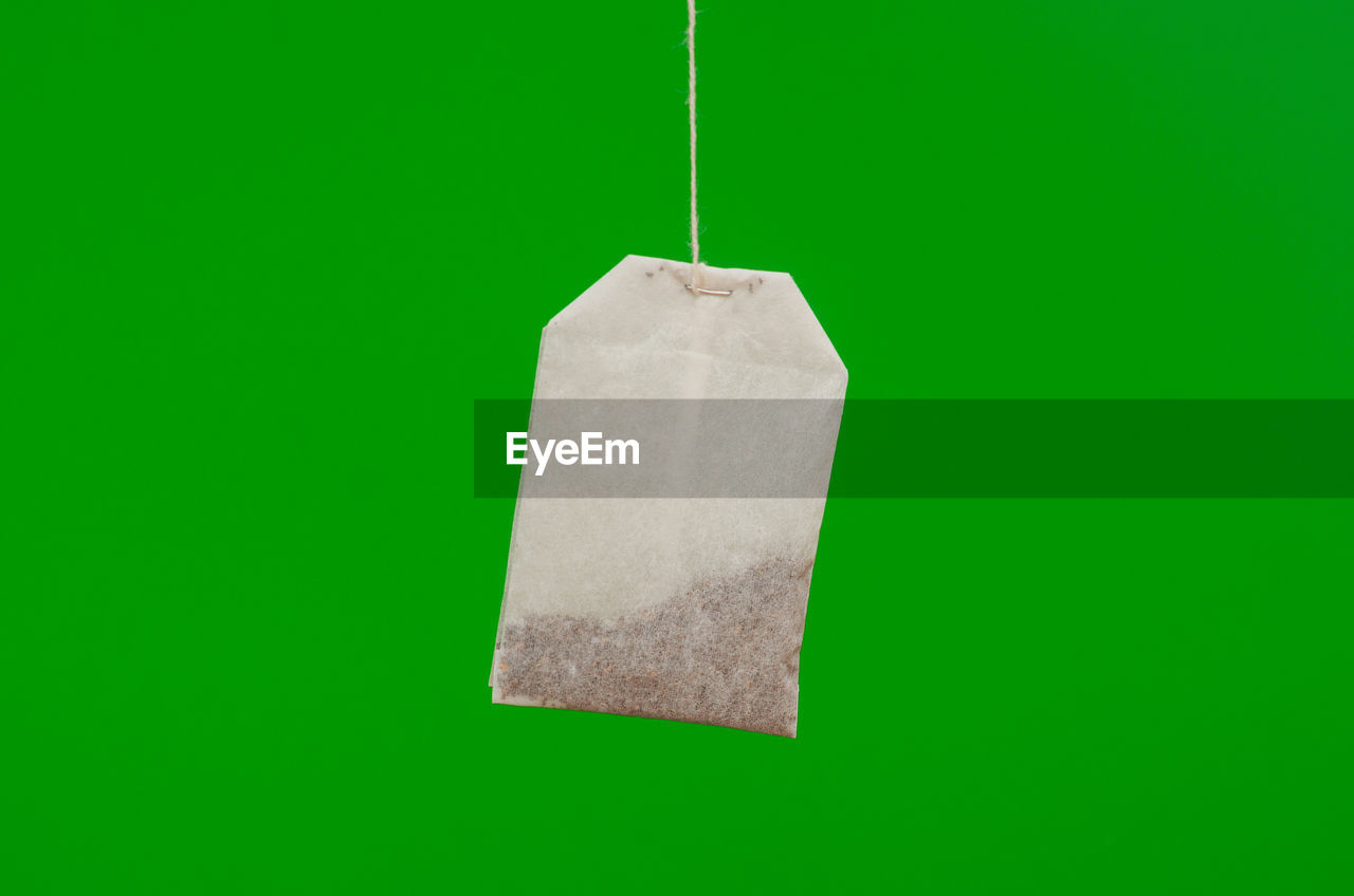 CLOSE-UP OF DRINK HANGING ON GREEN LEAF