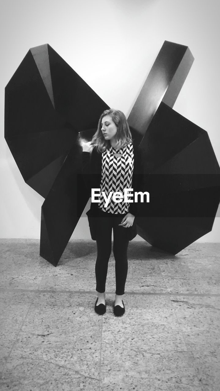 Young woman standing against built structure