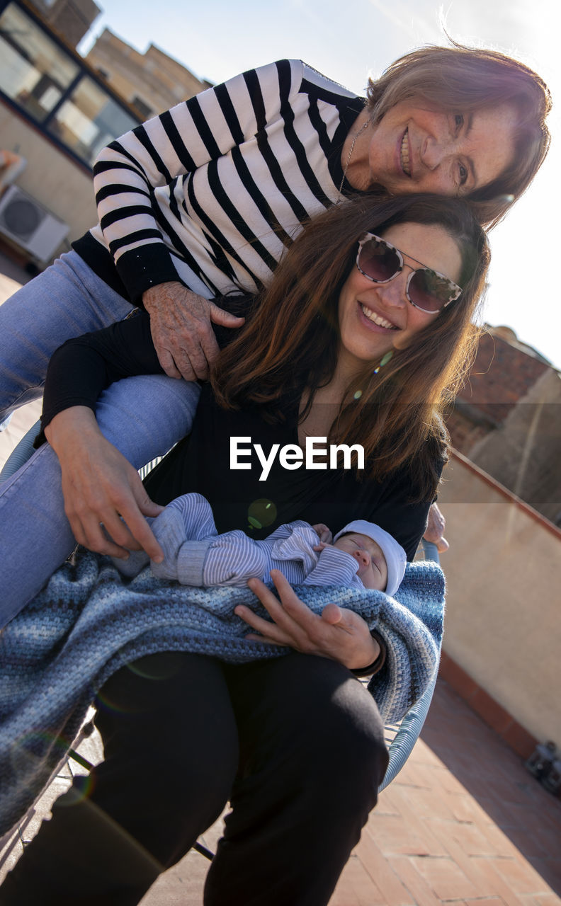 Portrait of smiling family sitting outdoors