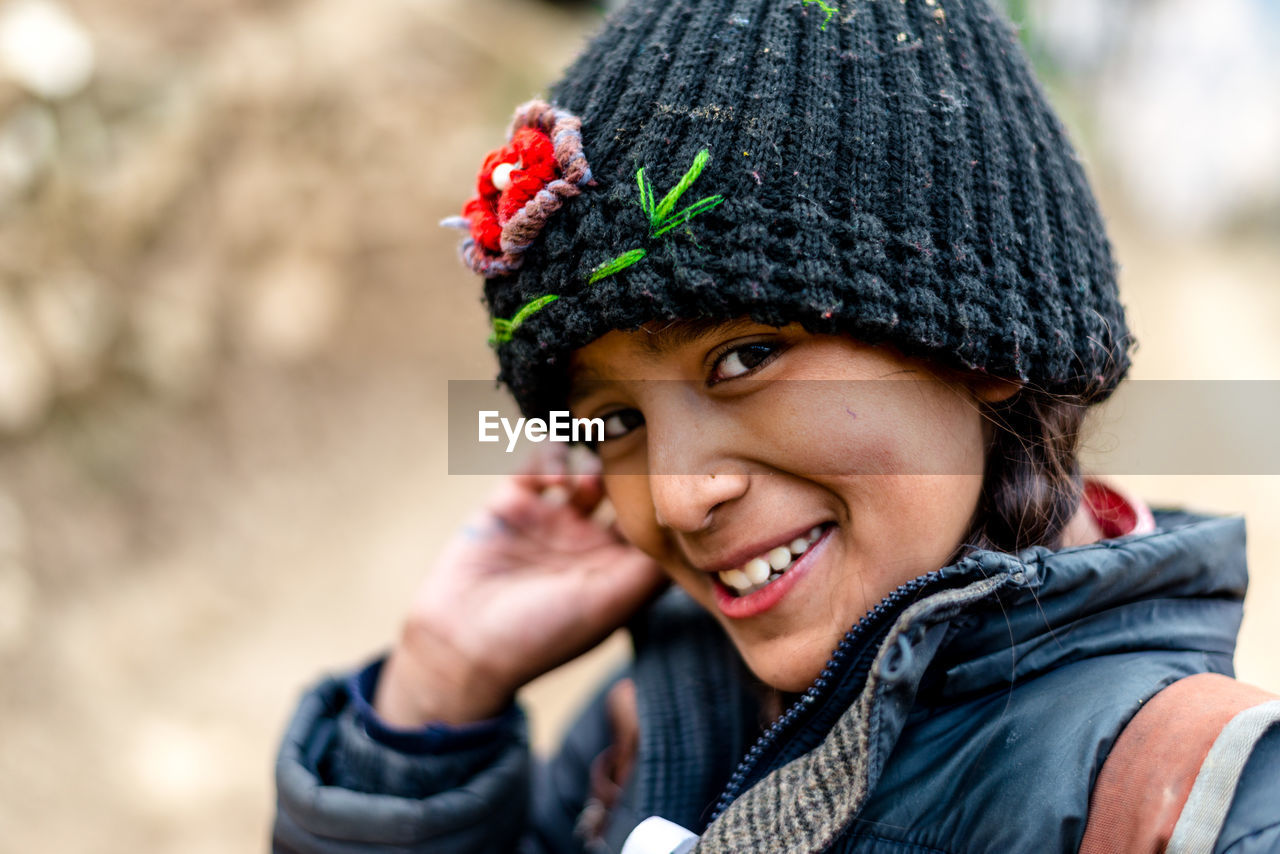 CLOSE-UP PORTRAIT OF SMILING BOY IN WINTER