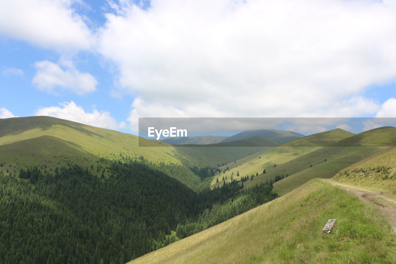 Scenic view of mountains against cloudy sky