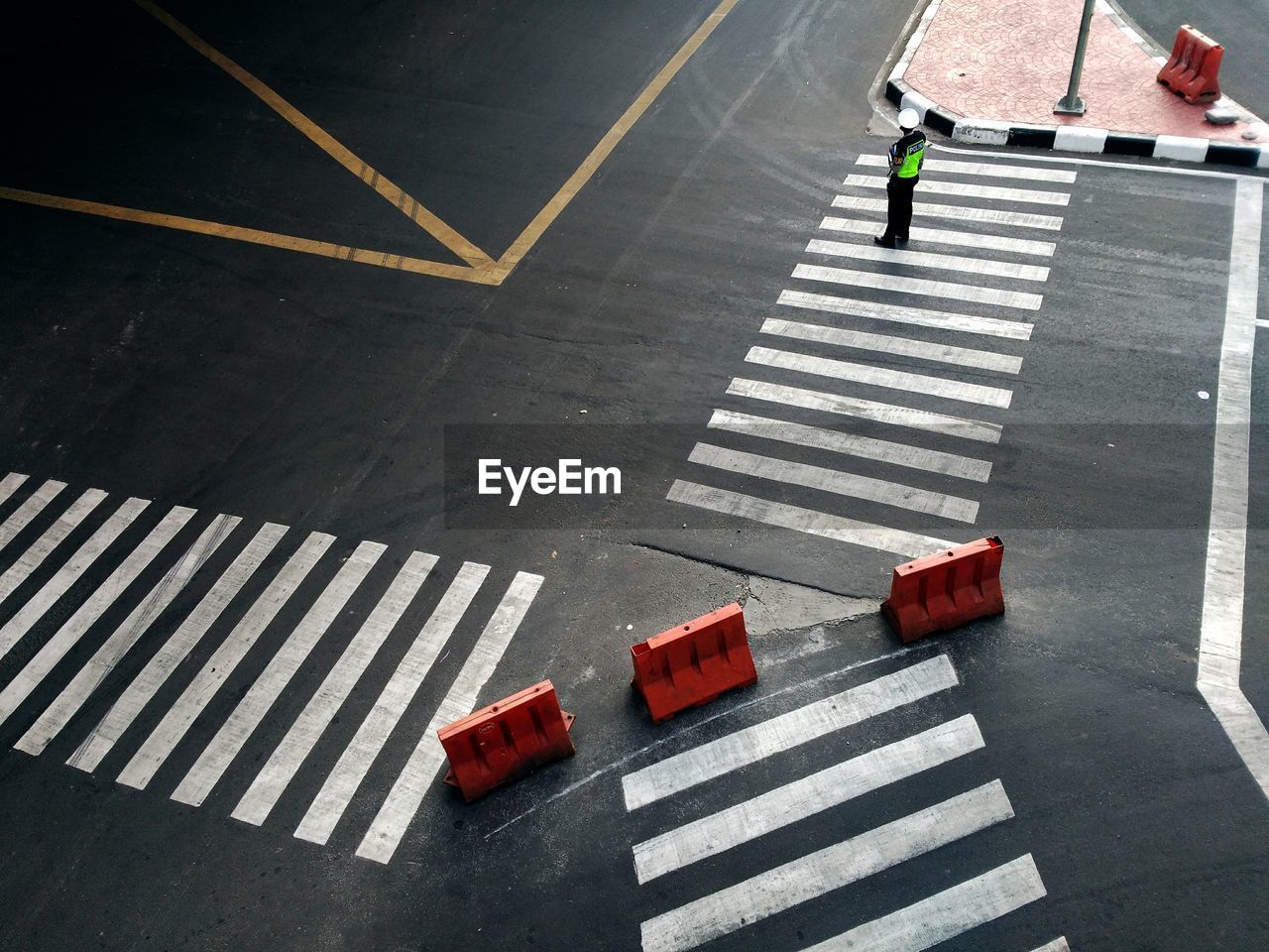 High angle view police man standing on zebra crossings in city