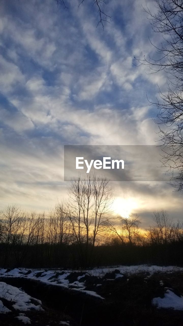 SNOW COVERED FIELD AGAINST SKY DURING SUNSET