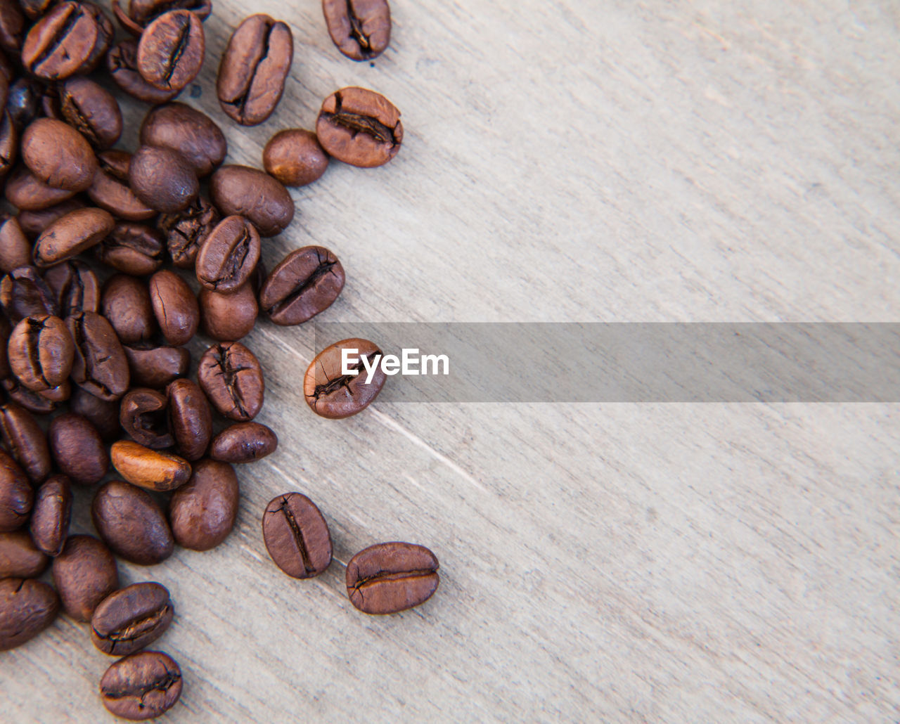 High angle view of roasted coffee beans on wooden table