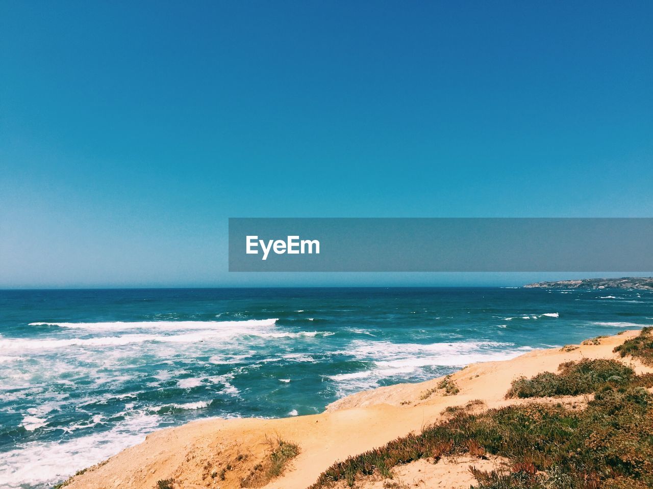 Scenic view of sea against clear blue sky