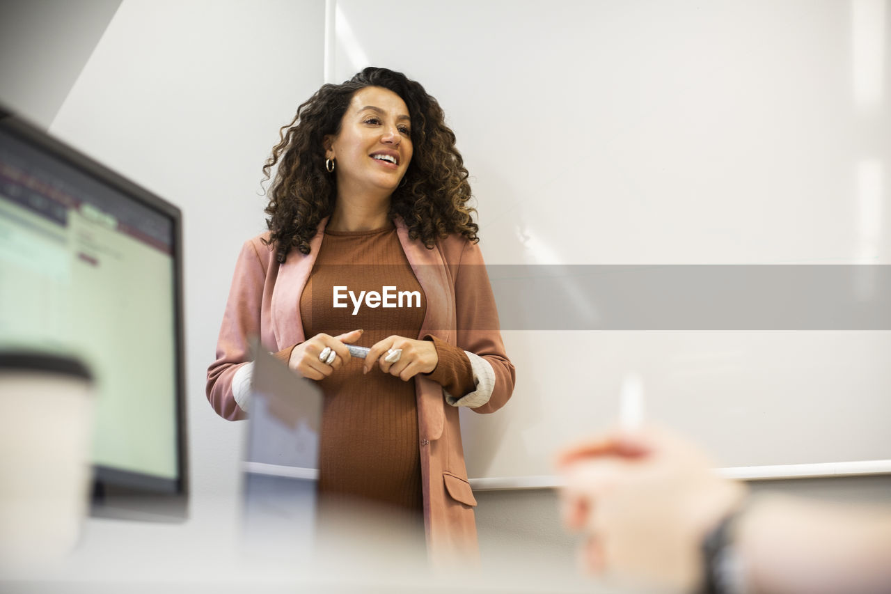 Smiling female entrepreneur in board room at office