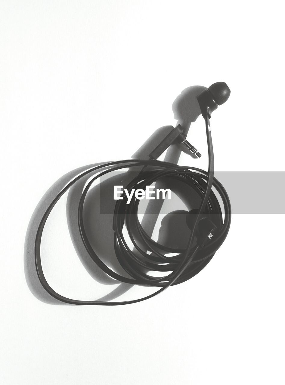 Close-up of black earphone over white background
