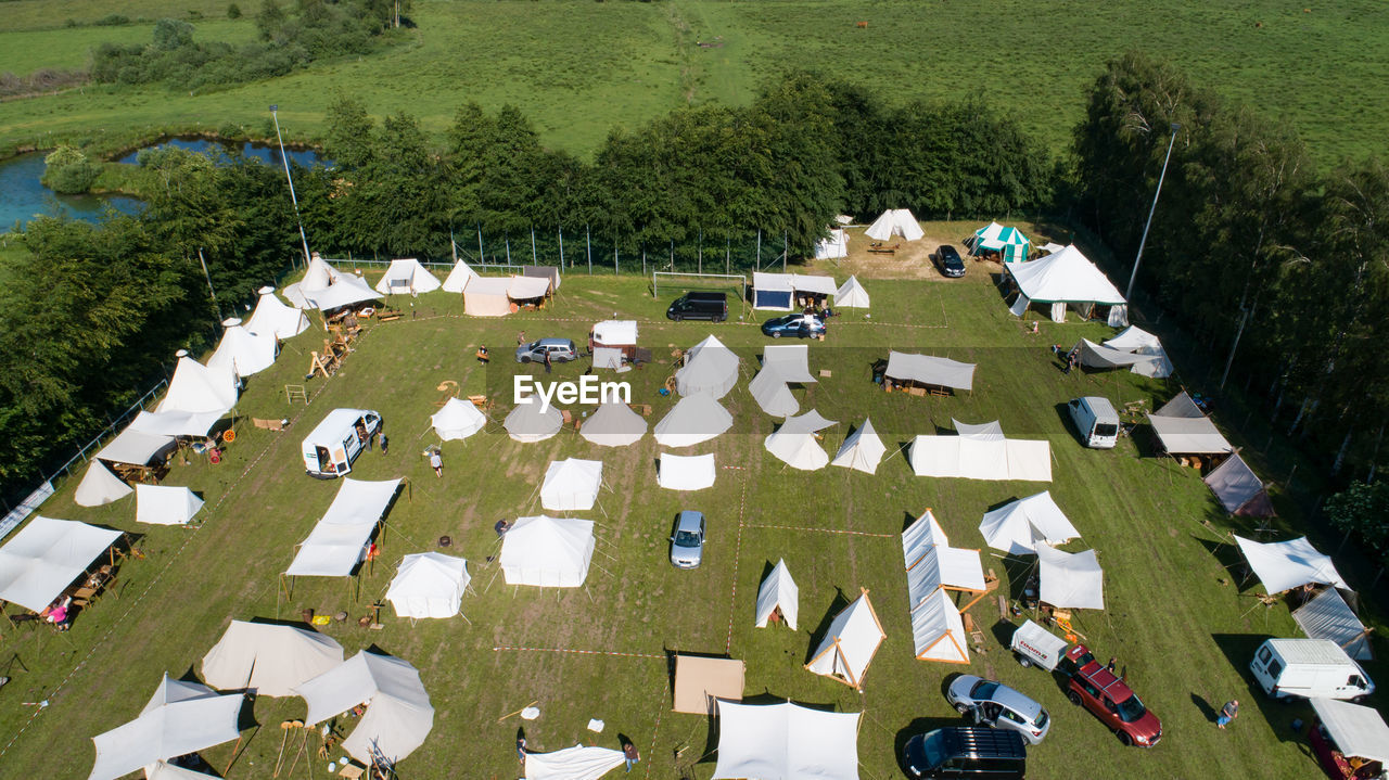 HIGH ANGLE VIEW OF PEOPLE ON FIELD AGAINST TREES AND PLANTS