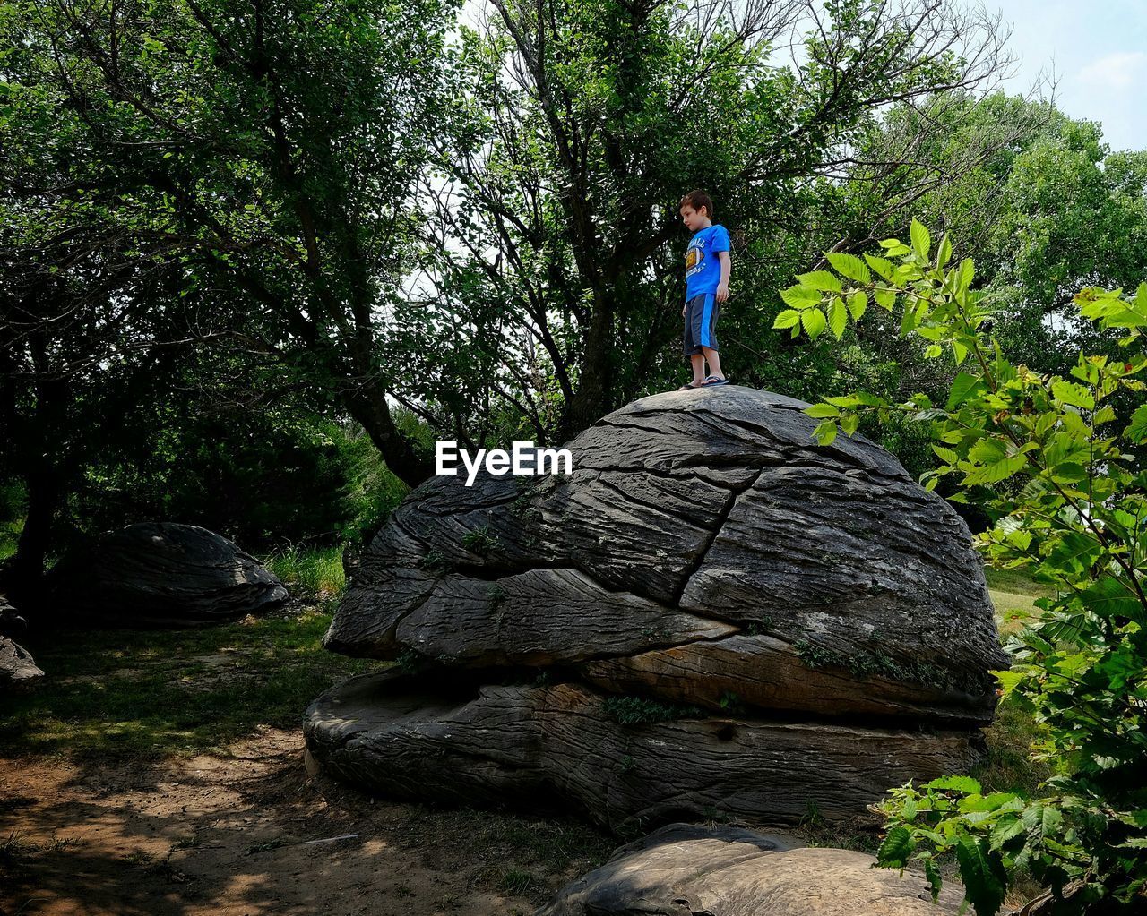 Low angle view of boy standing on rock