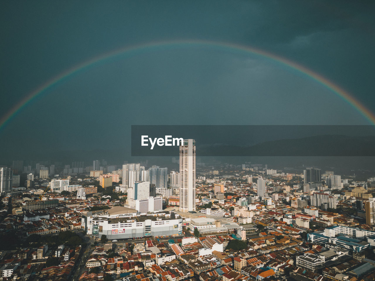 rainbow over cityscape against sky