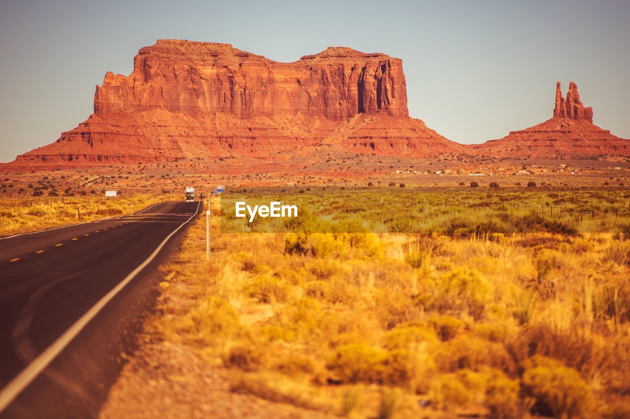 Road leading towards mountains against sky