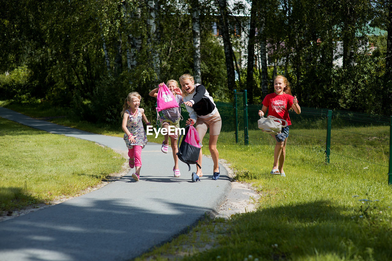 Siblings jumping over road in city