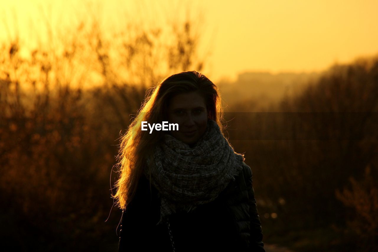 Woman standing on land during sunset