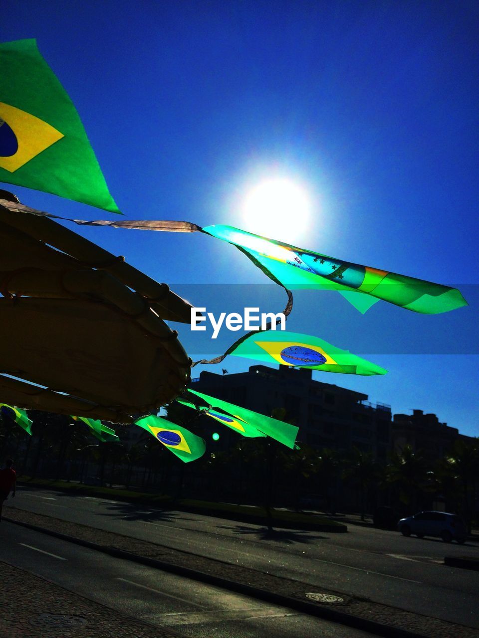 Brazilian flags hanging against blue sky
