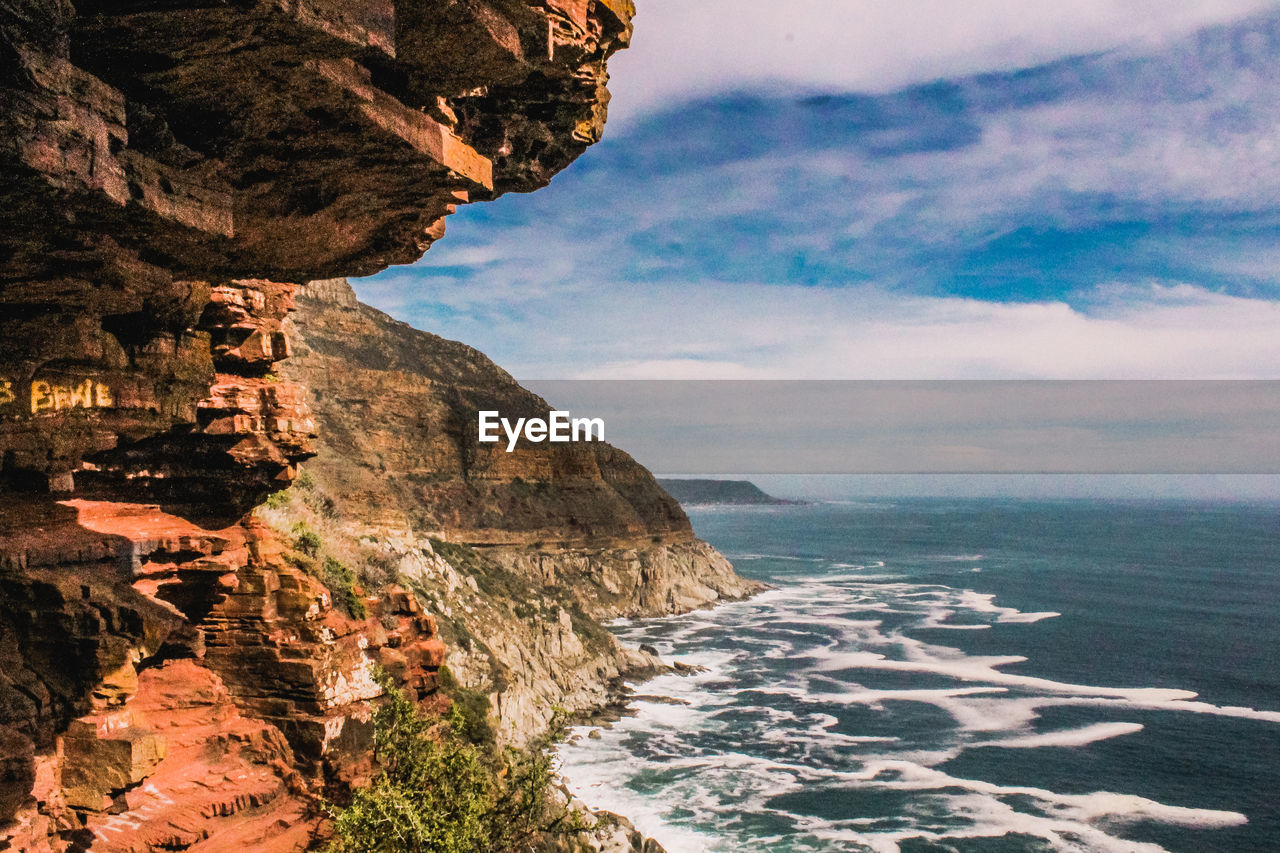 SCENIC VIEW OF SEA BY ROCK FORMATION AGAINST SKY