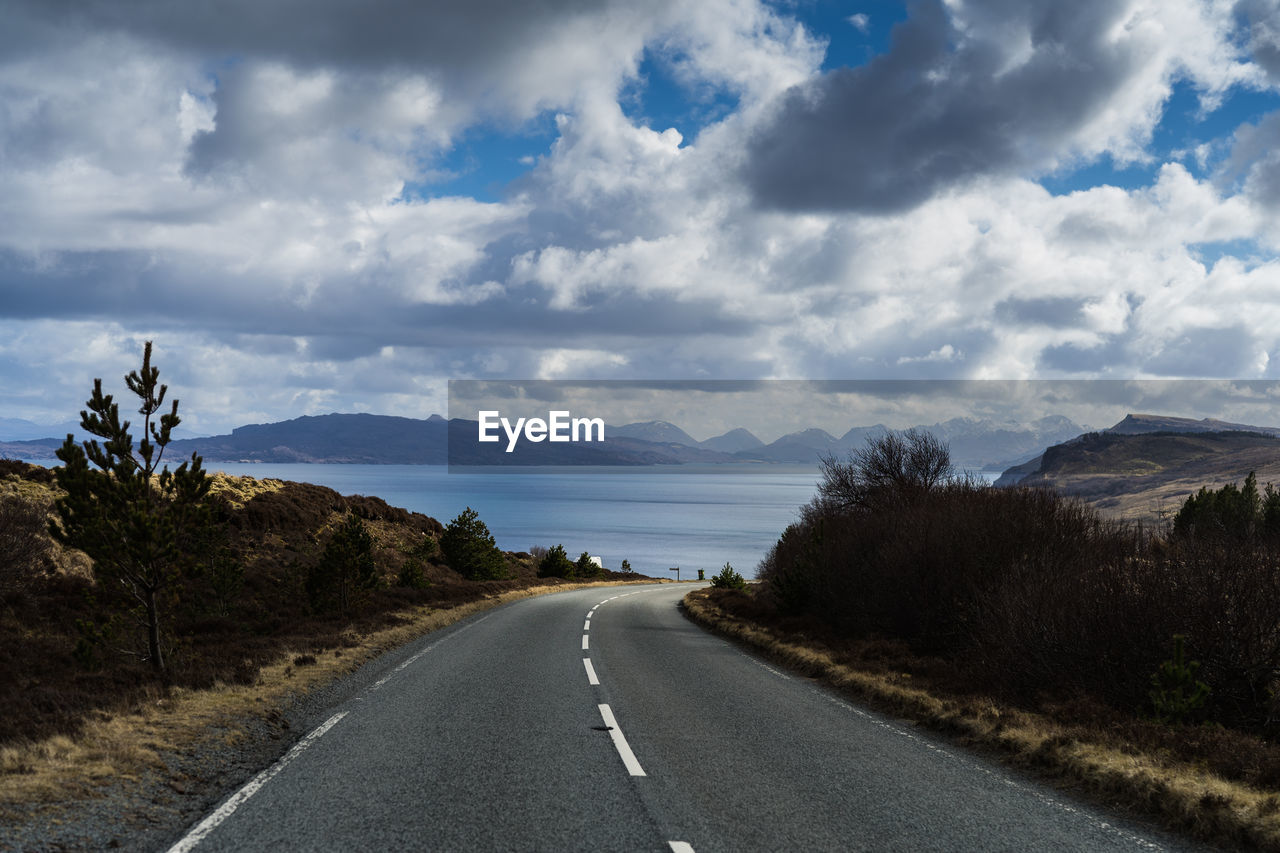 Empty road along landscape and mountains against sky