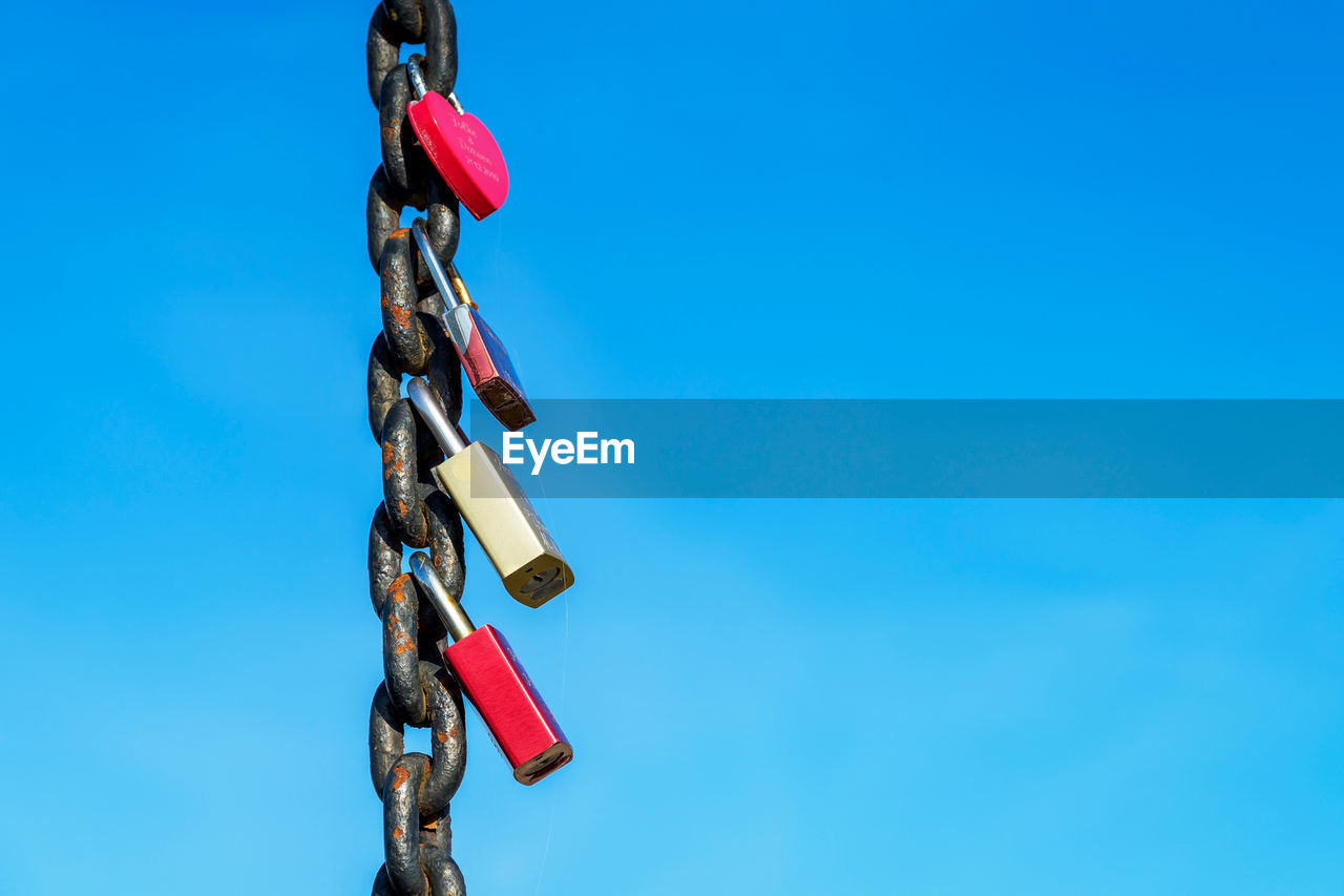 Love locks against clear blue sky