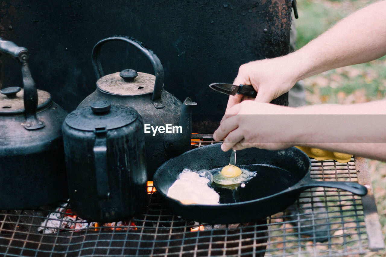 CLOSE-UP OF MAN PREPARING FOOD ON METAL